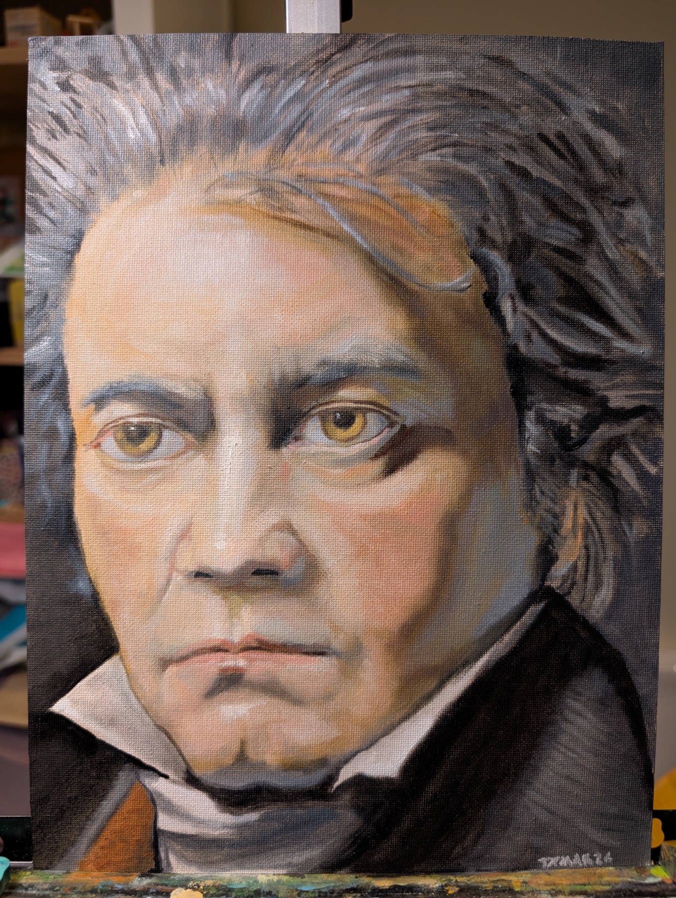 Portrait painting of Ludwig van Beethoven with amber eyes, grey-black hair, and a dark coat.